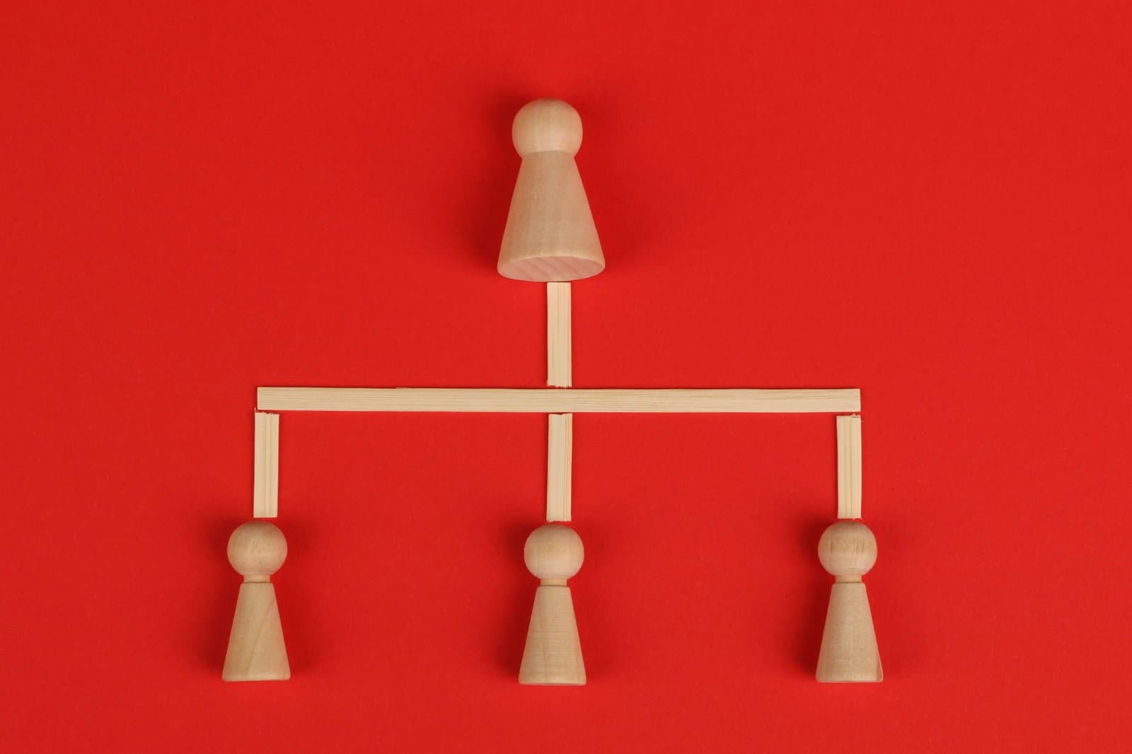 Wooden figures linked together like a network on a red background