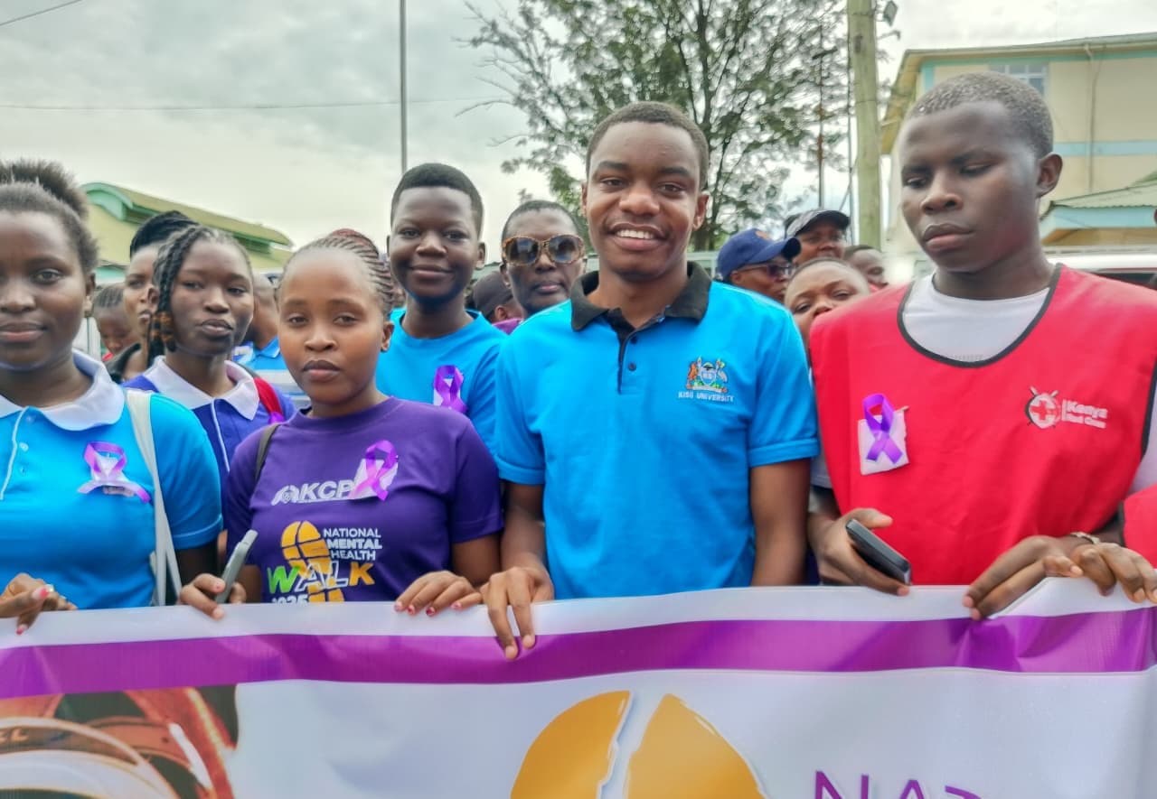 Smiling young people holding a banner at the National Mental Health Walk in Kisii